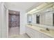 Bathroom with double vanity and patterned wall in the shower at 1540 Gulf Blvd # 2004, Clearwater, FL 33767