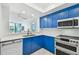 Modern kitchen with white quartz countertops and blue cabinets at 1540 Gulf Blvd # 2004, Clearwater, FL 33767