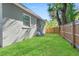 Backyard view showing house exterior, grassy area, and wooden fence at 1584 S Washington Ave, Clearwater, FL 33756