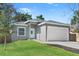 Newly constructed home with a gray exterior, white garage door, and well-manicured lawn at 1584 S Washington Ave, Clearwater, FL 33756