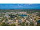 Aerial view of community with lake, pool, and buildings at 1882 Pine Ridge W Way # E1, Palm Harbor, FL 34684