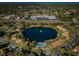 Aerial view of community with lake, pool, and buildings at 1882 Pine Ridge W Way # E1, Palm Harbor, FL 34684