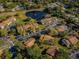 Aerial view of community with lake and buildings at 1882 Pine Ridge W Way # E1, Palm Harbor, FL 34684