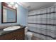 Bathroom with striped shower curtain and dark vanity at 1882 Pine Ridge W Way # E1, Palm Harbor, FL 34684