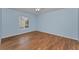 Light blue bedroom with wood-look tile flooring and ceiling fan at 1882 Pine Ridge W Way # E1, Palm Harbor, FL 34684