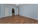 Light blue bedroom with wood-look floors and access to bathroom at 1882 Pine Ridge W Way # E1, Palm Harbor, FL 34684