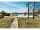 Peaceful lake view with walkway, fountain, and bench at 1882 Pine Ridge W Way # E1, Palm Harbor, FL 34684