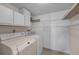 Laundry room with washer, dryer, and ample shelving at 1882 Pine Ridge W Way # E1, Palm Harbor, FL 34684