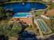 Aerial view of community pool, shuffleboard, and lake at 1882 Pine Ridge W Way # E1, Palm Harbor, FL 34684