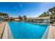 Relaxing community pool with patio seating at 1882 Pine Ridge W Way # E1, Palm Harbor, FL 34684