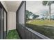 Screened-in porch with artificial turf and view of landscaping at 1882 Pine Ridge W Way # E1, Palm Harbor, FL 34684