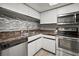 Galley kitchen with stainless steel appliances and stone backsplash at 1955 Whitney Way, Clearwater, FL 33760