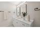 Bright bathroom boasts double vanity with gold fixtures and white cabinets at 2004 Virginia Dr, Bradenton, FL 34205