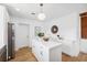 Modern white kitchen with island, stainless steel appliances, and light wood flooring at 2004 Virginia Dr, Bradenton, FL 34205