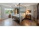 Main bedroom with four-poster bed, wood floors, and window view at 2022 Hawkhurst Cir, Sun City Center, FL 33573