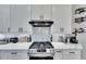 Modern kitchen with white cabinets and gas cooktop at 204 Latitude Pl, Apollo Beach, FL 33572