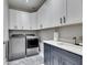 Laundry room with white cabinets, a utility sink, and modern appliances at 204 Latitude Pl, Apollo Beach, FL 33572