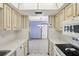 View through kitchen to dining area, white appliances and light wood cabinets at 2300 Lancaster Dr, Clearwater, FL 33764