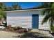 White detached garage with blue door, landscaping, and paver driveway at 2660 Miriam S St, Gulfport, FL 33711