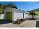 White detached garage with green door, landscaping, and paver walkway at 2660 Miriam S St, Gulfport, FL 33711