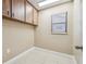 Small laundry room with wood cabinets and tile floor at 2715 Narcissus Dr, Holiday, FL 34691