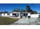 Ranch-style home with a covered porch, landscaped yard, and solar panels at 2801 Auburn W Ave, Tampa, FL 33614