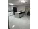 White kitchen with large island, breakfast bar, and marble flooring at 2801 Auburn W Ave, Tampa, FL 33614