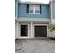 Exterior of a charming townhome with a dark gray garage door and light gray stone driveway at 2878 Grand Kemerton Pl, Tampa, FL 33618