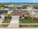 Bird's-eye view of a tan house, two-car garage, and neighborhood at 3190 Shoreline Dr, Clearwater, FL 33760