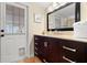 Bathroom with dark brown vanity, large mirror, and exterior access at 3190 Shoreline Dr, Clearwater, FL 33760