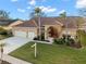 Tan two-story house with a three-car garage and palm trees at 3190 Shoreline Dr, Clearwater, FL 33760