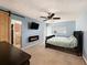 Main bedroom with a large bed, electric fireplace, and ensuite bathroom access at 3245 Canal Pl, Land O Lakes, FL 34639