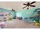 Bright playroom with light teal walls, two ceiling fans, and ample space for toys at 3245 Canal Pl, Land O Lakes, FL 34639