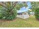 Landscaped backyard with a large tree and white picket fence at 3405 Nixon Rd, Holiday, FL 34691