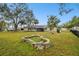 Spacious backyard with a stone fire pit and mature trees at 3915 W Pearl Ave, Tampa, FL 33611