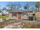 House exterior with red door and mature trees at 3915 W Pearl Ave, Tampa, FL 33611