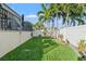 Landscaped backyard with grassy area, palm trees, and white fence at 3925 1St Ne St, St Petersburg, FL 33703