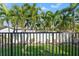 View of a backyard with lush palm trees and a fence at 3925 1St Ne St, St Petersburg, FL 33703