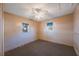 Simple bedroom with carpet, ceiling fan, and two windows at 4135 4Th N Ave, St Petersburg, FL 33713