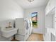 Laundry room with white sink, washer, dryer, and built-in shelving at 4320 Middle Lake Dr, Tampa, FL 33624