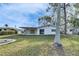 Backyard view of a single-story home with mature trees at 4730 Shore Acres Ne Blvd, St Petersburg, FL 33703