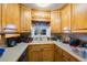 Galley style kitchen, with wood cabinets, a double sink and a window at 5290 38Th S Way, St Petersburg, FL 33711