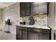 Stylish kitchen featuring dark cabinetry, marble counters, and patterned wallpaper at 5453 Del Coronado Dr, Apollo Beach, FL 33572