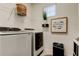 Convenient laundry room with modern washer and dryer, shelving, and a stylish sign at 5453 Del Coronado Dr, Apollo Beach, FL 33572