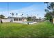 A lush backyard with a freeform pool, patio, lush lawn, and trees complements the house with its enclosed sunroom at 5600 Bayou Grande Ne Blvd, St Petersburg, FL 33703