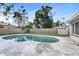 Backyard showcasing a private pool with a concrete deck, spacious lawn, and a secure wooden fence at 5600 Bayou Grande Ne Blvd, St Petersburg, FL 33703