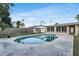 Serene backyard featuring a refreshing in-ground pool, surrounded by green grass, and privacy fence at 5600 Bayou Grande Ne Blvd, St Petersburg, FL 33703