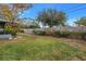 Grass backyard with a wooden fence and mature trees at 6623 16Th N St, St Petersburg, FL 33704