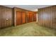 Bedroom with wood paneled walls and green carpet at 6623 16Th N St, St Petersburg, FL 33704