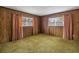 Bedroom with wood paneled walls and green carpet at 6623 16Th N St, St Petersburg, FL 33704